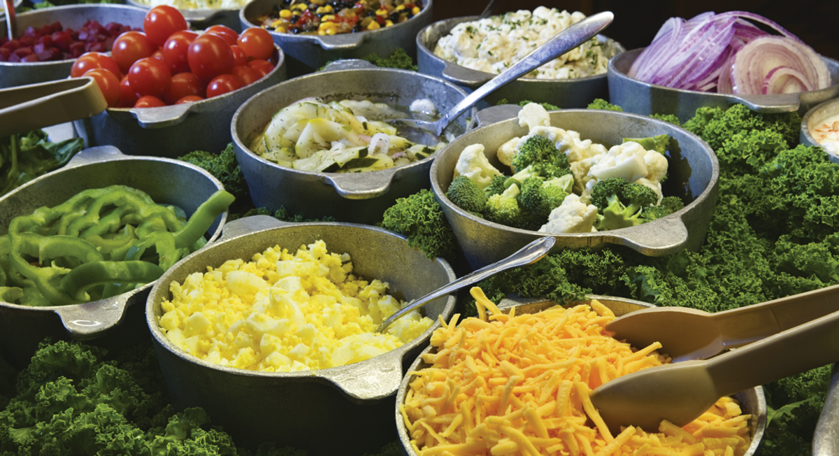 Beautifully arranged food display with a variety of hot and cold dishes prepared by Enck's Plus Catering